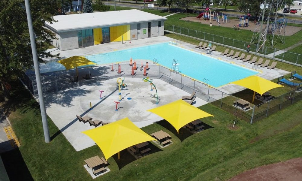 Les nouvelles installations comprennent un bâtiment de services, un bassin principal, une aire de jeux d’eau et des plages en béton, des espaces de détente ainsi qu’un aménagement paysager. Photo : Courtoisie