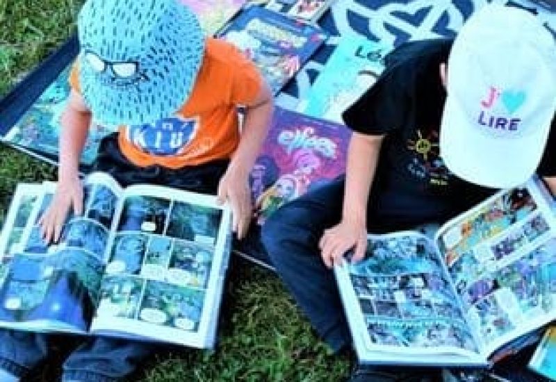 Enfants en train de lire à l'extérieur