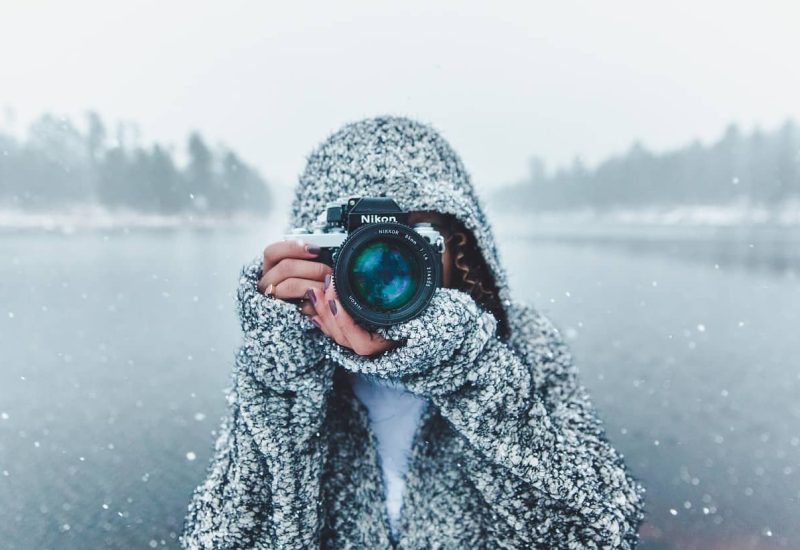 une femme prenant une photo en plein hiver