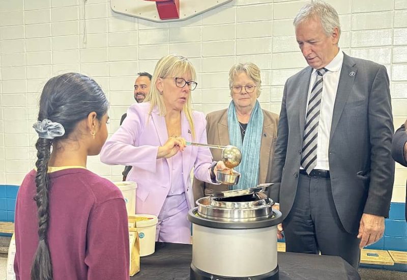 La députée Isabelle Poulet sert une soupe à un enfant à l'annonce de la Tablée des Chefs, accompagnée des ministres Chantal Rouleau et André Lamontagne. Photo: Courtoisie