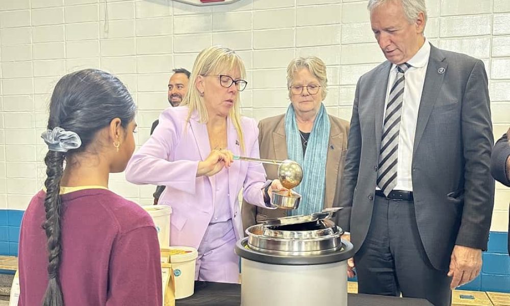 La députée Isabelle Poulet sert une soupe à un enfant à l'annonce de la Tablée des Chefs, accompagnée des ministres Chantal Rouleau et André Lamontagne. Photo: Courtoisie