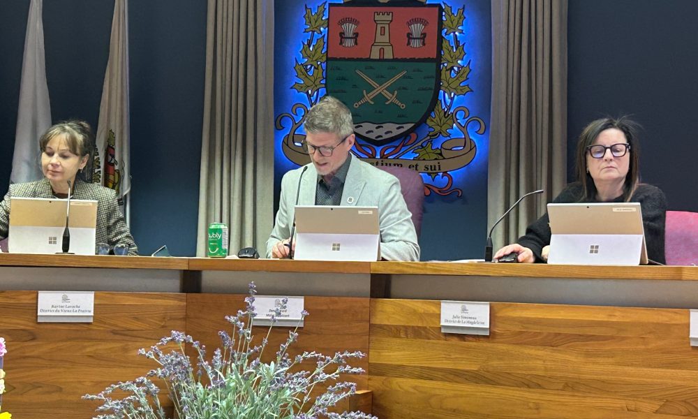 fm1033,projet,Poirier,La Prairie,cnostruction,réalisation,affaires,promoteur,partenaires,habitation,unités,types,développement,eaux,fleuve,logements,budgets,maire,moratoire,chantier,taxe,municipalité