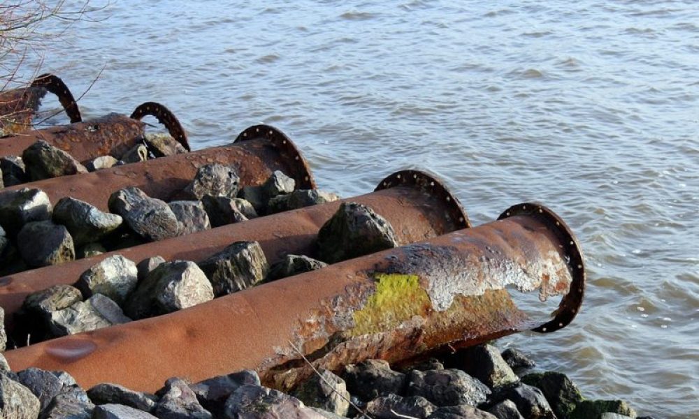 Des tuyaux de déversement d'eaux usées au-dessus d'un cours d'eau.