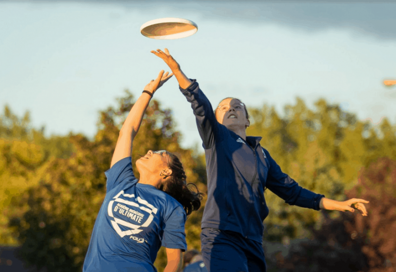 Deux personnes se disputent un Frisbee