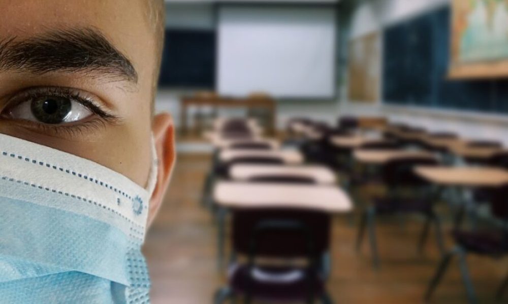 Un étudiant masqué dans une classe.