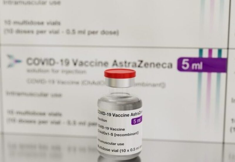 Une fiole du vaccin AstraZeneca devant une boîte du vaccin.